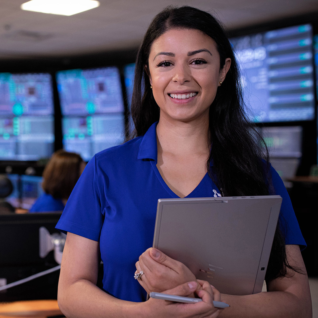 NuScale employee standing with clipboard in control room. 