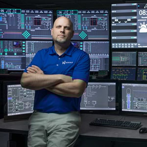 Employee standing in front of screens inside E2 Center.